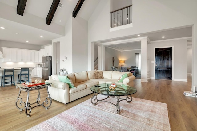 living room with high vaulted ceiling, visible vents, light wood-style floors, and beamed ceiling