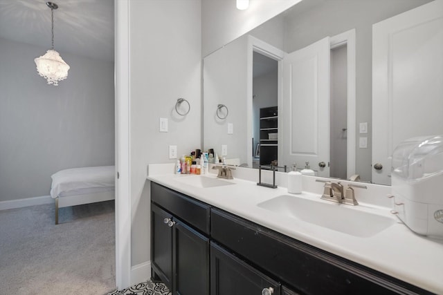 ensuite bathroom with baseboards, a sink, ensuite bath, and double vanity