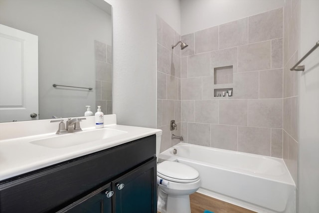 full bathroom featuring toilet, shower / bath combination, wood finished floors, and vanity