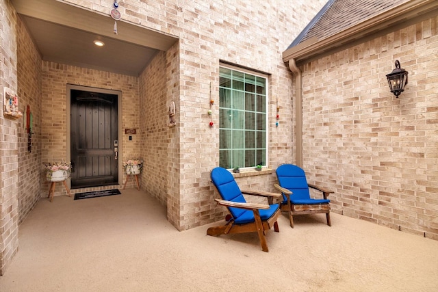 entrance to property featuring a patio area and brick siding