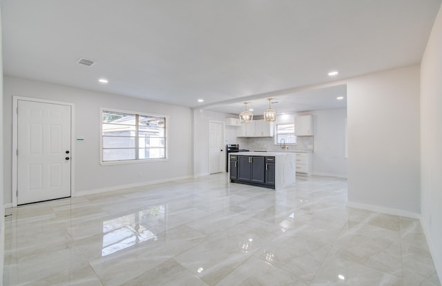 kitchen featuring decorative light fixtures, visible vents, light countertops, open floor plan, and white cabinetry