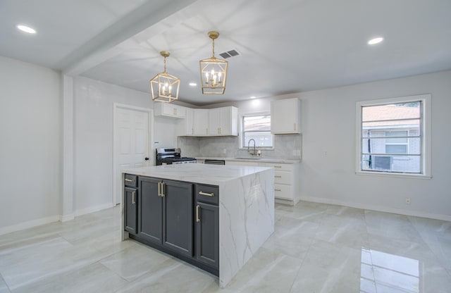 kitchen with a center island, stainless steel electric range oven, hanging light fixtures, white cabinetry, and light stone countertops