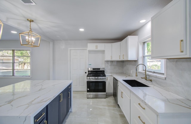 kitchen with decorative light fixtures, blue cabinets, stainless steel appliances, white cabinetry, and a sink