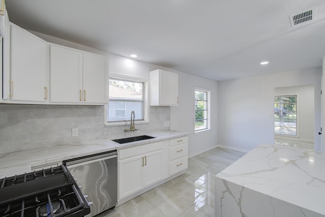 kitchen featuring visible vents, stainless steel dishwasher, gas stove, white cabinetry, and a sink