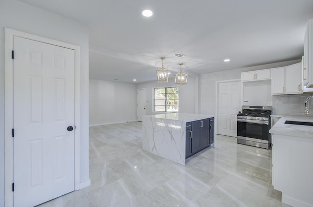 kitchen featuring a kitchen island, white cabinets, hanging light fixtures, blue cabinetry, and stainless steel range with gas stovetop