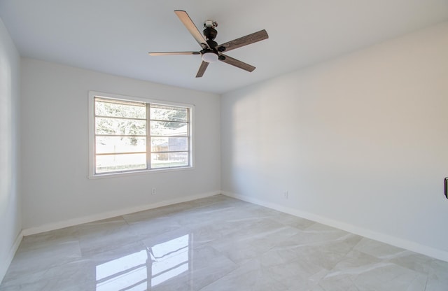 unfurnished room with ceiling fan and baseboards