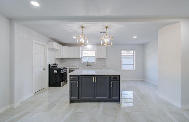 kitchen featuring a sink, white cabinets, backsplash, gas stove, and decorative light fixtures