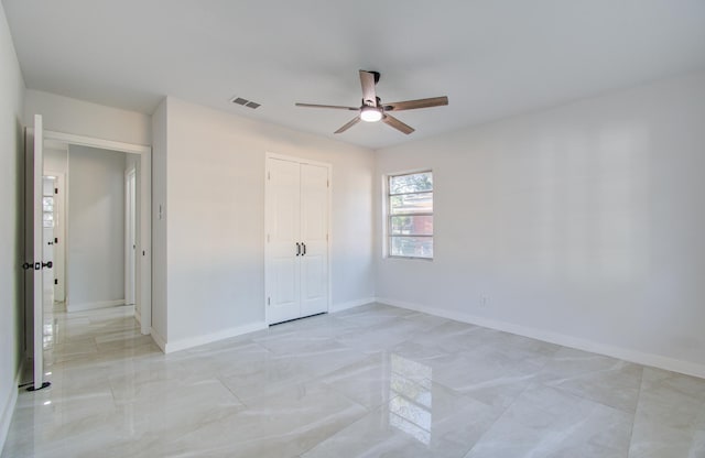 unfurnished bedroom with a ceiling fan, baseboards, visible vents, and a closet