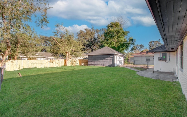 view of yard featuring an outbuilding, a patio area, and a fenced backyard