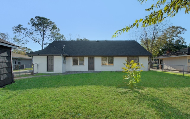 rear view of property featuring fence and a lawn