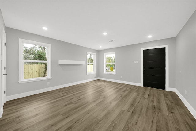 unfurnished room featuring visible vents, baseboards, wood finished floors, and recessed lighting