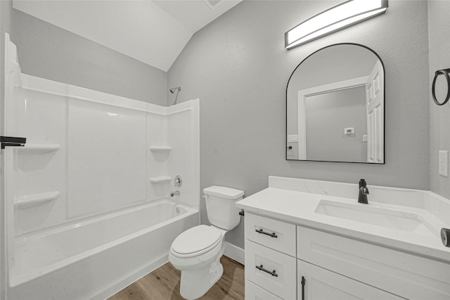 bathroom with bathtub / shower combination, toilet, vaulted ceiling, vanity, and wood finished floors