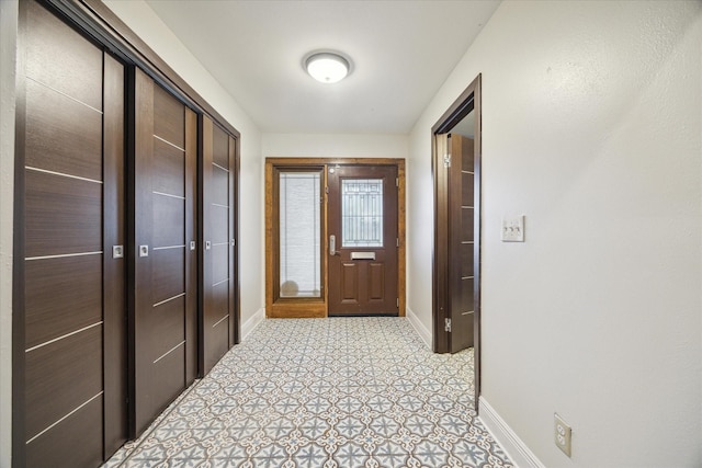 interior space featuring light floors and baseboards