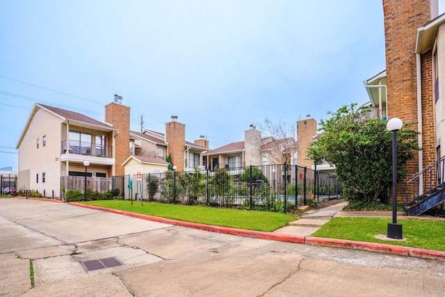 view of building exterior with a residential view and fence