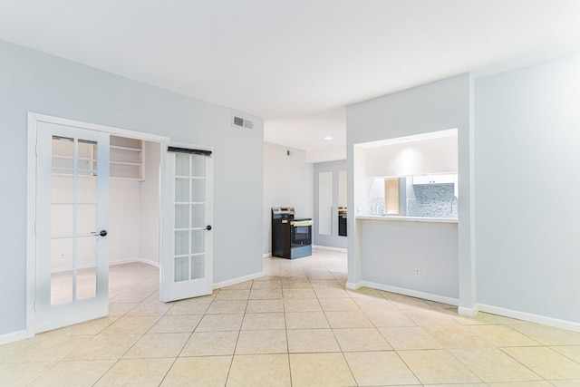 spare room featuring light tile patterned floors, baseboards, visible vents, and french doors