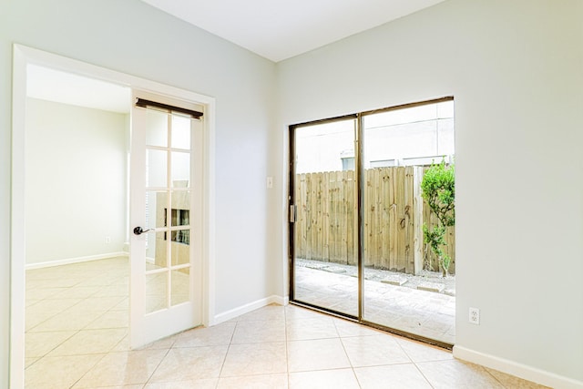 doorway with light tile patterned floors, baseboards, and french doors