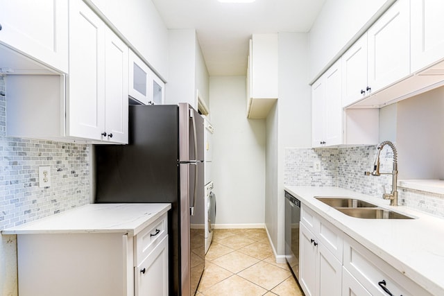 kitchen with light tile patterned floors, a sink, white cabinetry, appliances with stainless steel finishes, and decorative backsplash