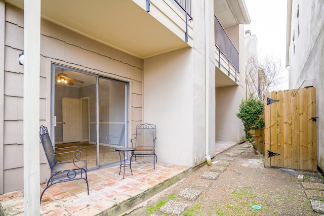 view of exterior entry with fence and a patio