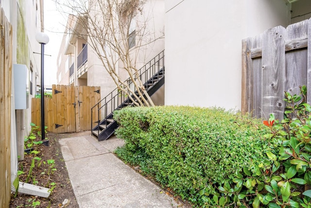 exterior space featuring a gate, fence, and stairs