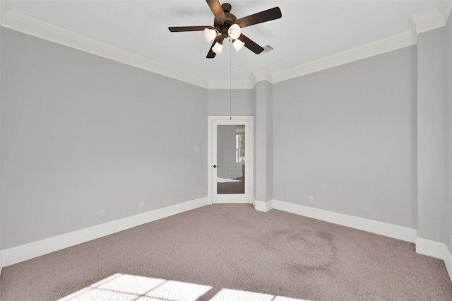 unfurnished room with carpet floors, crown molding, baseboards, and a ceiling fan