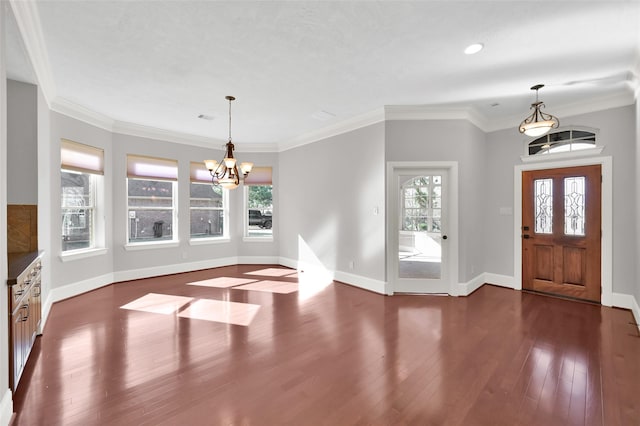 entryway with crown molding, an inviting chandelier, dark wood finished floors, and baseboards