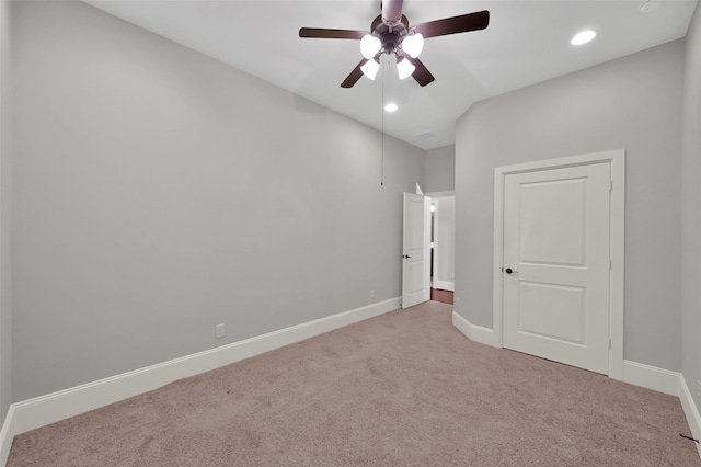 unfurnished bedroom featuring light carpet, baseboards, a ceiling fan, vaulted ceiling, and recessed lighting