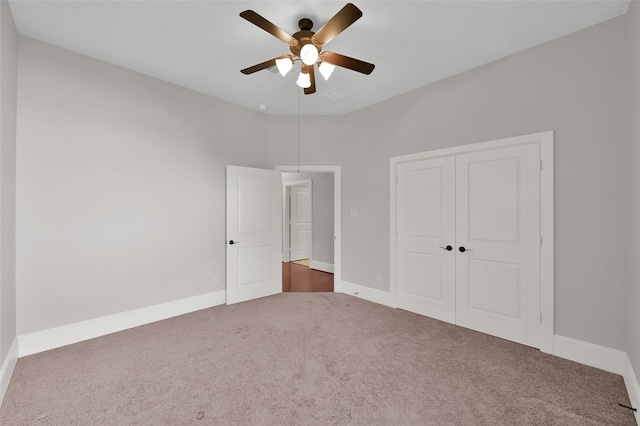 unfurnished bedroom featuring dark colored carpet, a closet, and baseboards