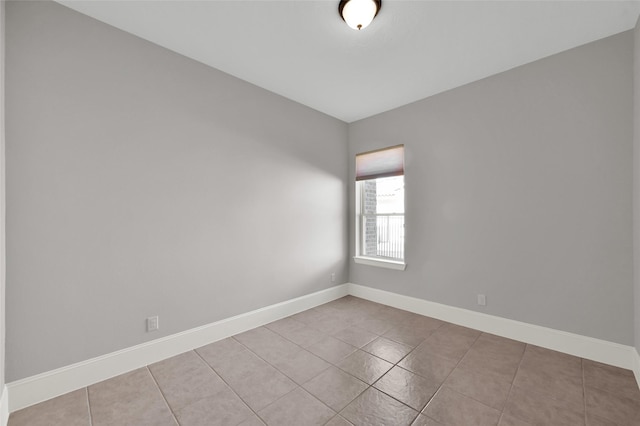 spare room with light tile patterned floors and baseboards