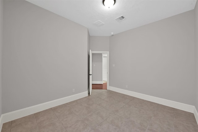 unfurnished room featuring visible vents and baseboards