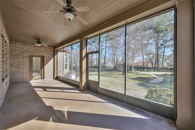 unfurnished sunroom featuring a healthy amount of sunlight and ceiling fan