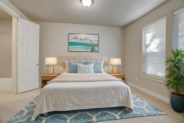 bedroom featuring light carpet and baseboards