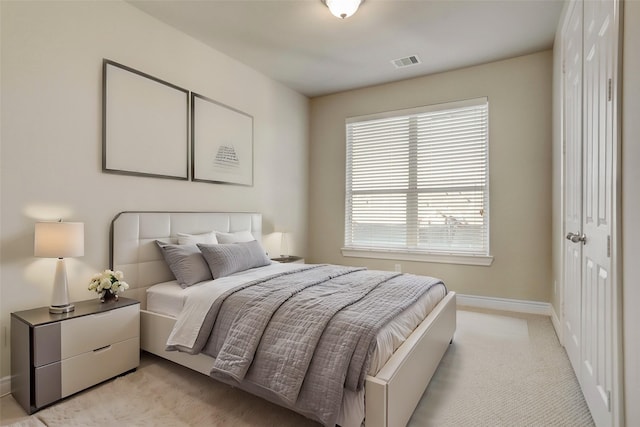 bedroom featuring light carpet, visible vents, and baseboards