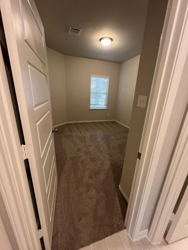 interior space featuring light colored carpet, visible vents, and baseboards