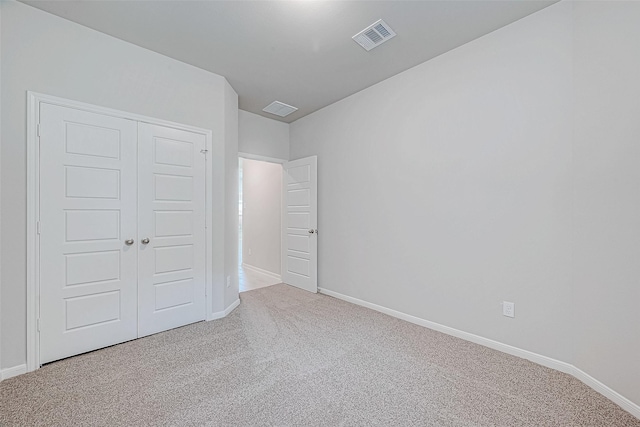 unfurnished bedroom featuring carpet, a closet, visible vents, and baseboards