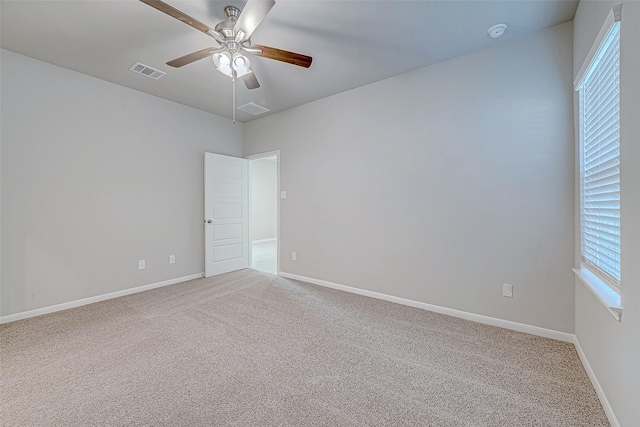 unfurnished room featuring ceiling fan, carpet floors, visible vents, and baseboards