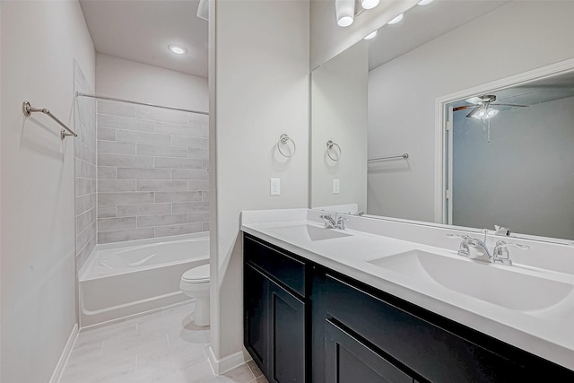 full bath with toilet, double vanity, a ceiling fan, and a sink