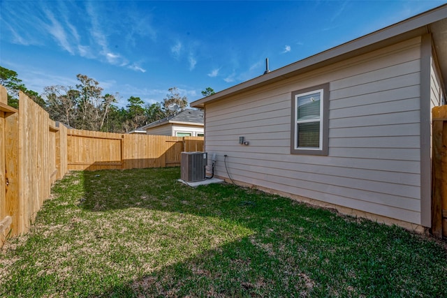 view of yard with a fenced backyard and central air condition unit