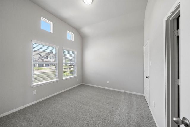 unfurnished room with carpet floors, baseboards, and vaulted ceiling