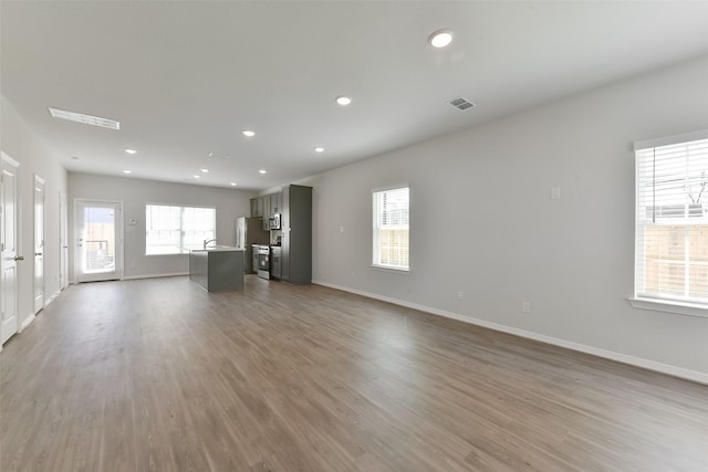 6835 New York St, Houston, TX 77021 - unfurnished living room featuring recessed lighting, visible vents, baseboards, and wood finished floors