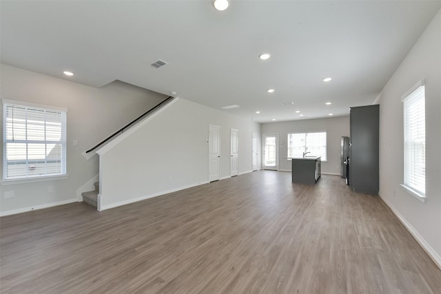 6835 New York St, Houston, TX 77021 - unfurnished living room featuring baseboards, visible vents, stairway, wood finished floors, and recessed lighting