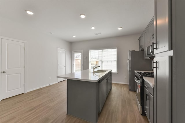 6835 New York St, Houston, TX 77021 - kitchen featuring a center island with sink, stainless steel appliances, a sink, and light countertops