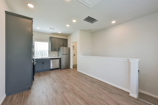6835 New York St, Houston, TX 77021 - kitchen with visible vents, decorative backsplash, baseboards, appliances with stainless steel finishes, and light wood-style floors