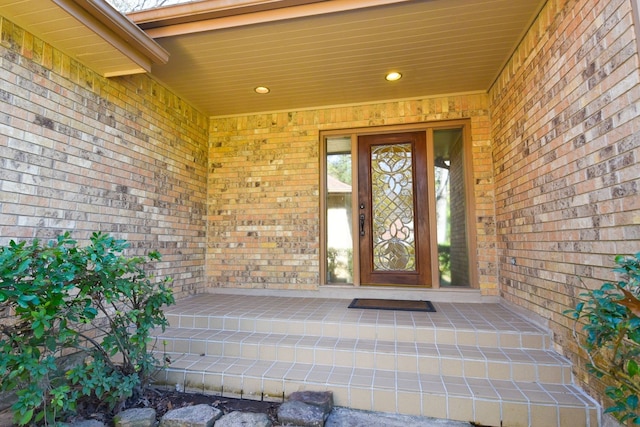 entrance to property featuring brick siding