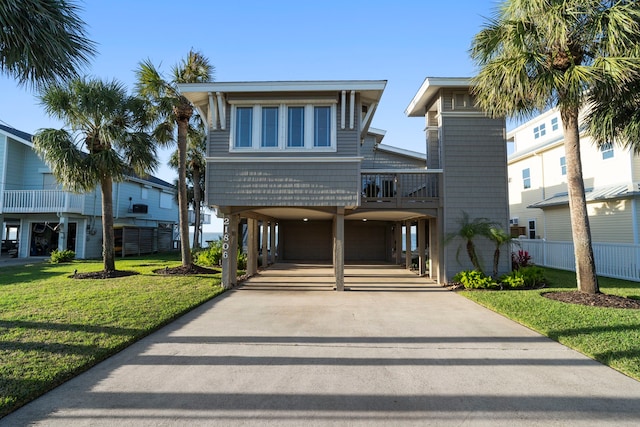 beach home with a carport, driveway, and a front lawn