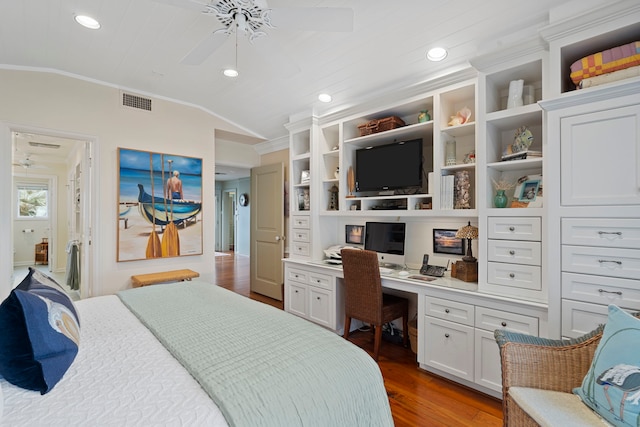 bedroom with lofted ceiling, visible vents, ornamental molding, built in study area, and wood finished floors