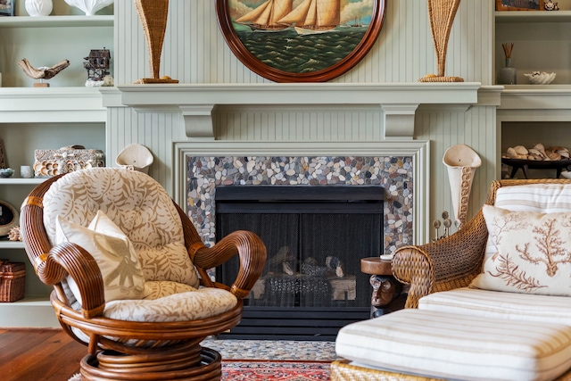 sitting room with wood finished floors and a tile fireplace