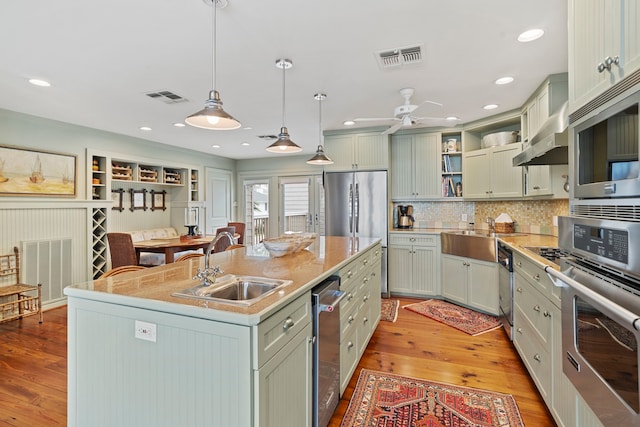 kitchen featuring open shelves, visible vents, stainless steel appliances, and a sink