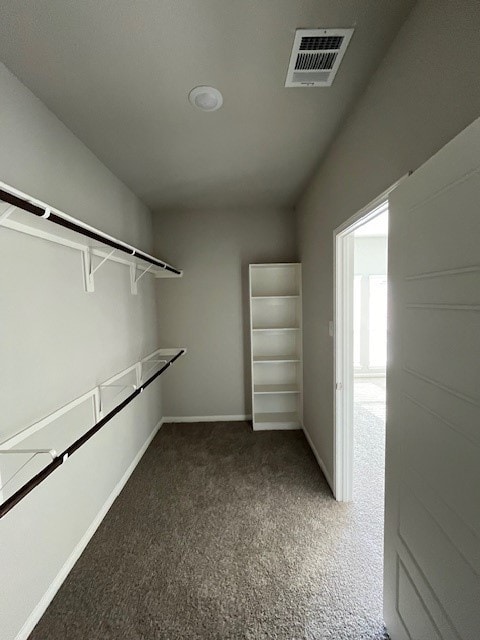 walk in closet with visible vents and dark carpet