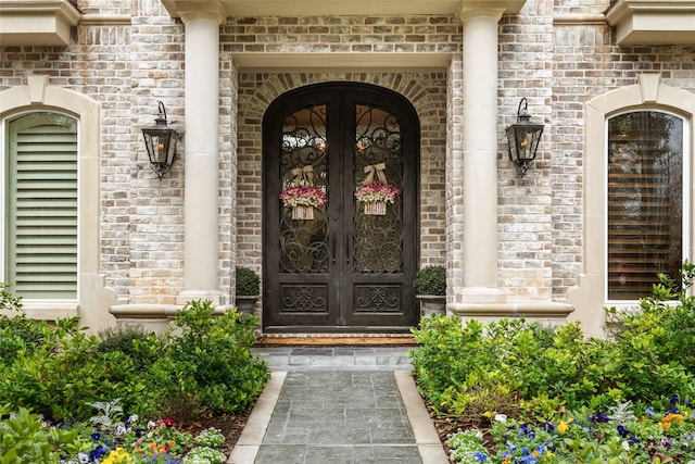 property entrance featuring brick siding and french doors