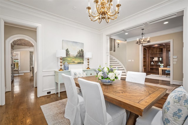 dining space featuring a chandelier, stairs, ornamental molding, wood finished floors, and arched walkways